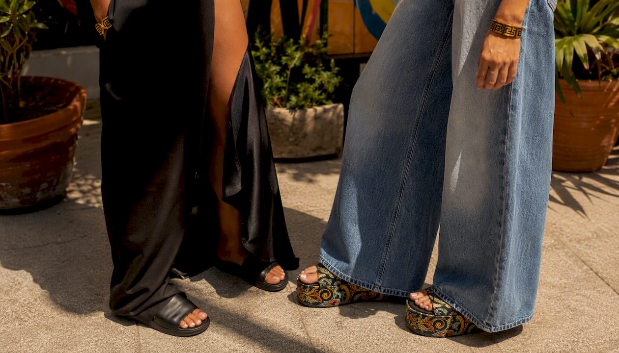 Minimal leather slides with tailored outfits close-up