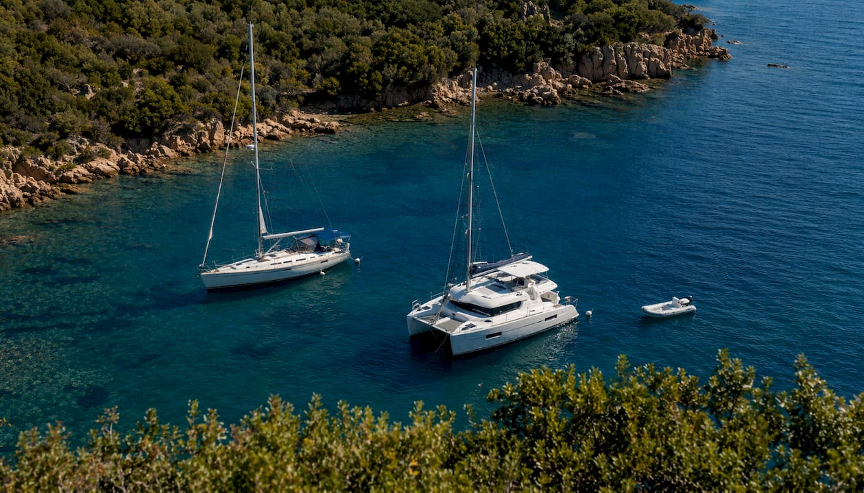 Vista dall’alto di diverse tipologie di barche a vela ormeggiate nella baia