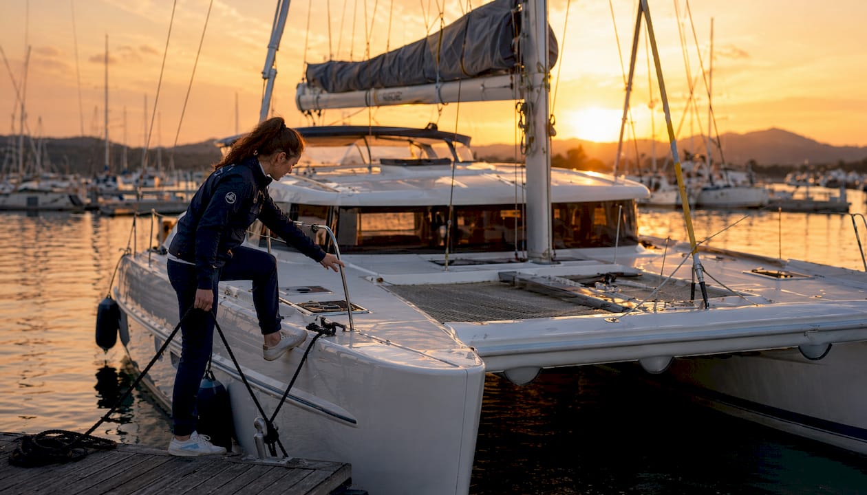 Una donna sale a bordo di un catamarano nel porto di Olbia.