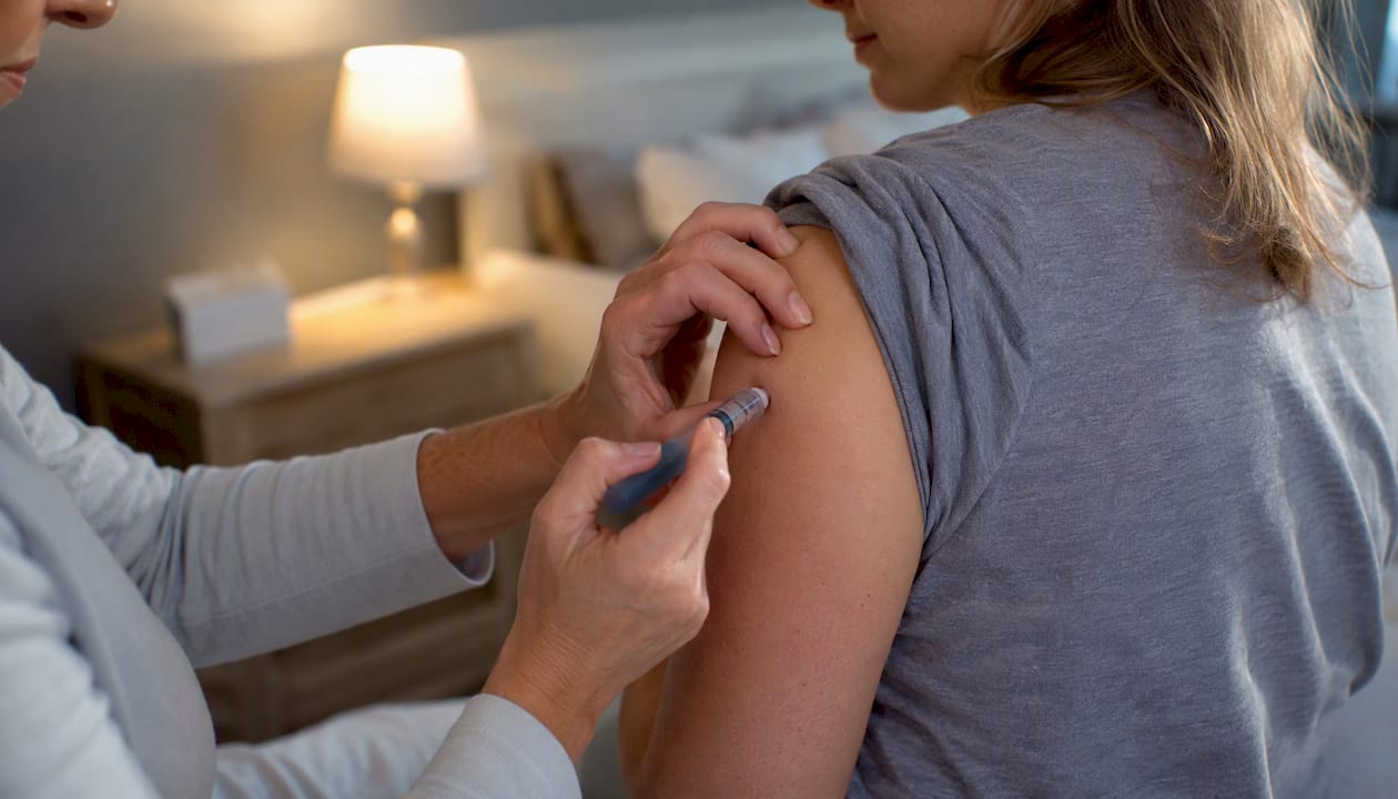 Caregiver assisting injection into upper arm