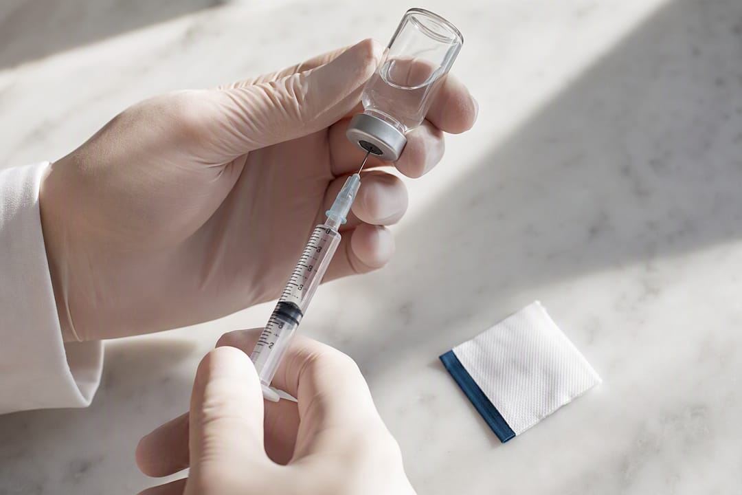Unlabeled vial beside calibrated syringe