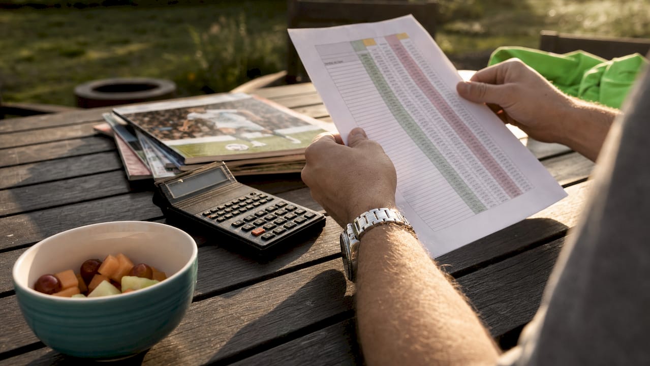 Close-up of hands managing betting bankroll documents