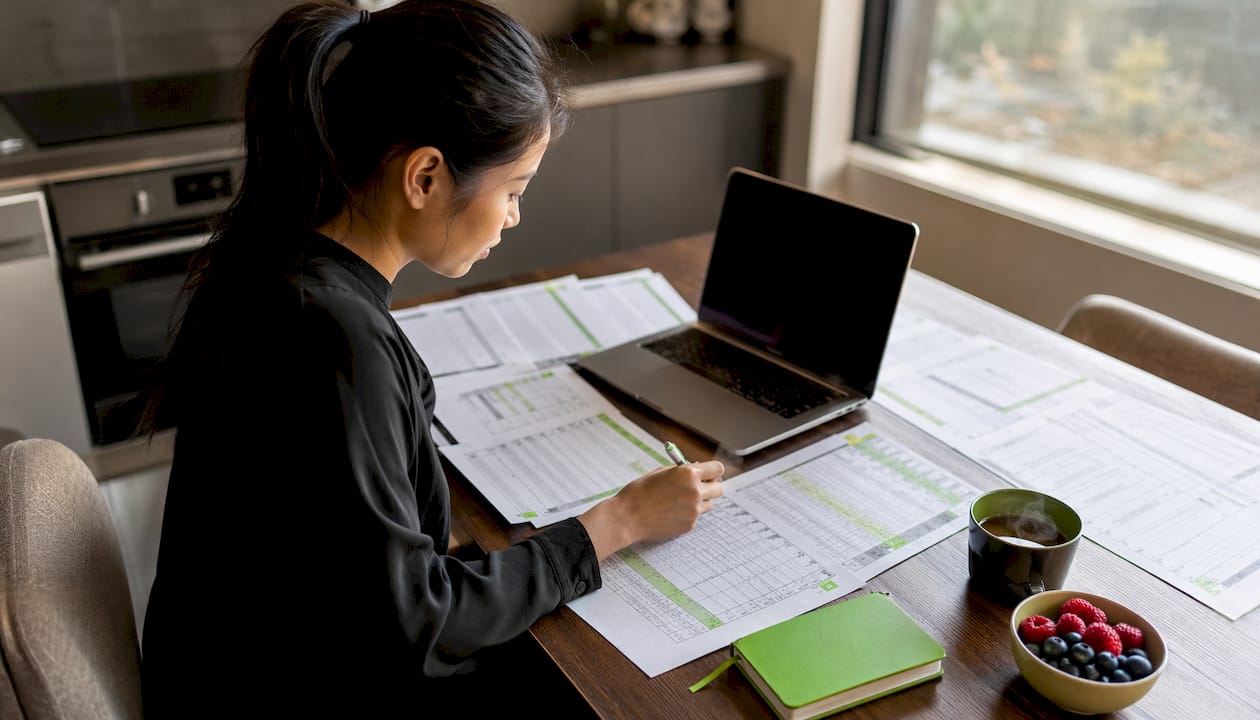 Woman analyzing sports betting data at desk