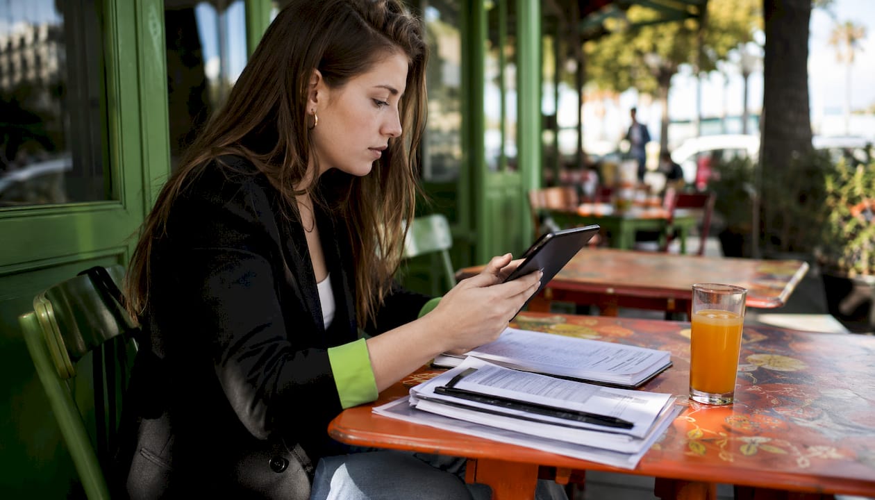 Woman reviewing NBA player props at café table