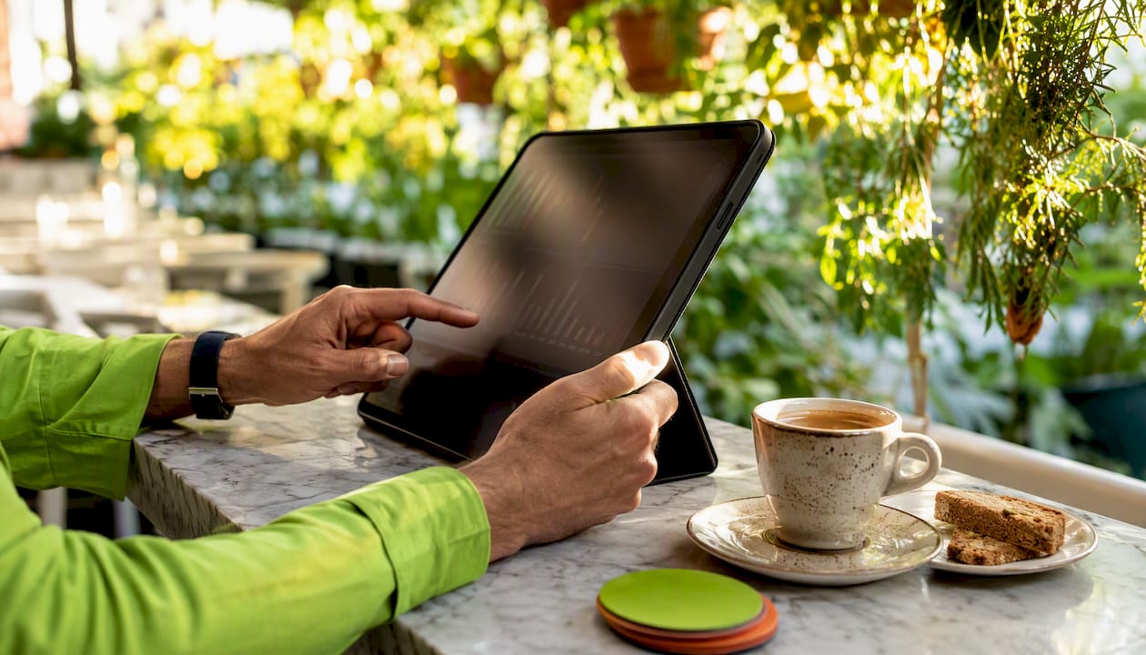 Hands interacting with betting app tablet in café
