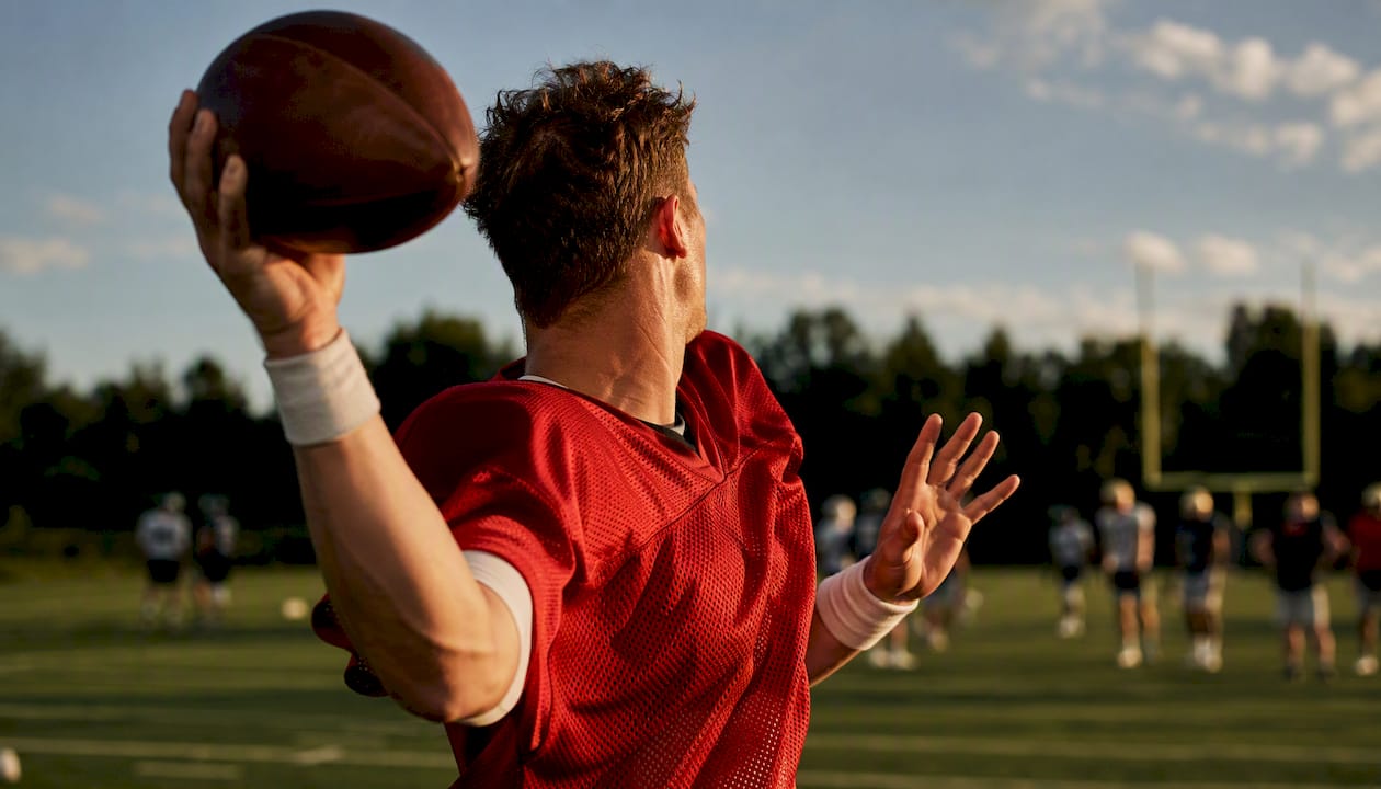 Quarterback mid-throw on football field