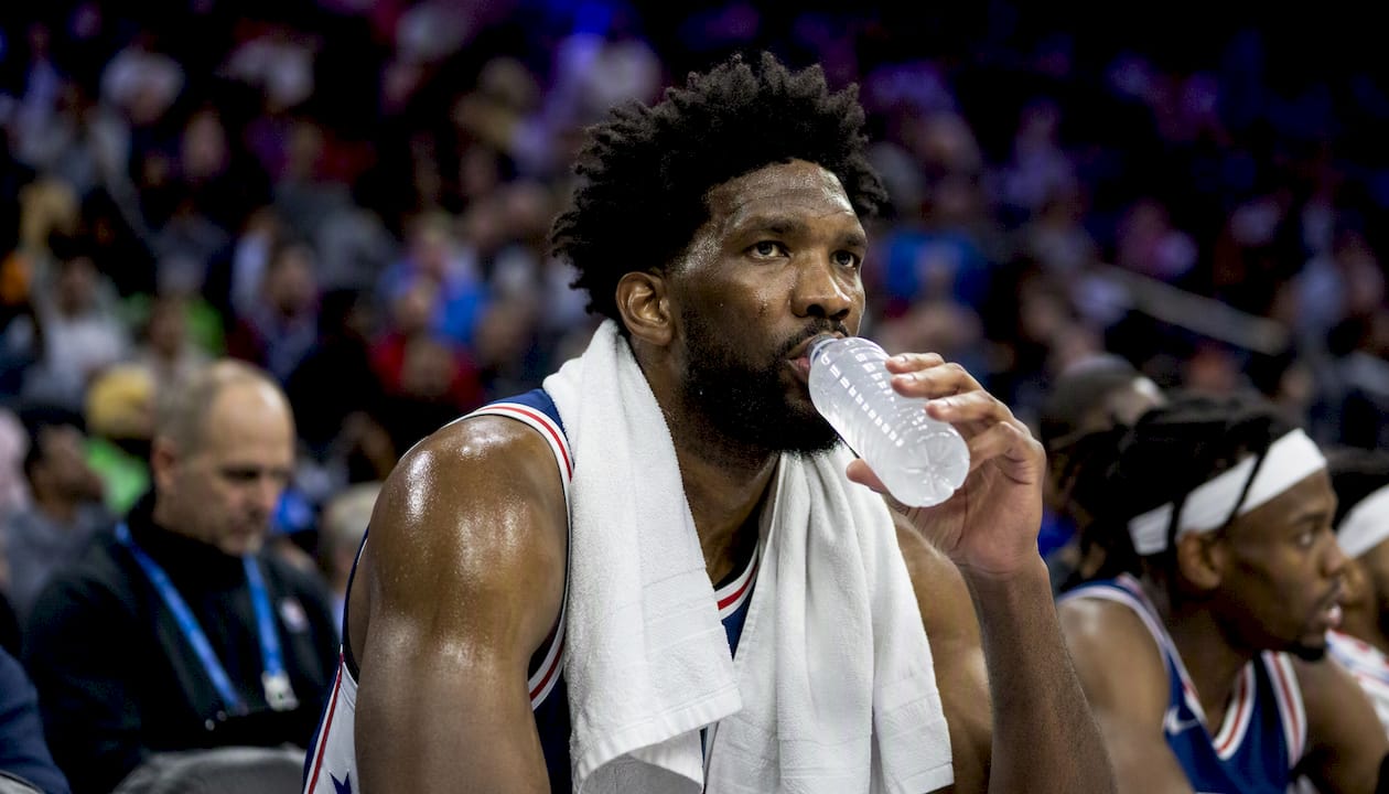 NBA player resting on bench with towel