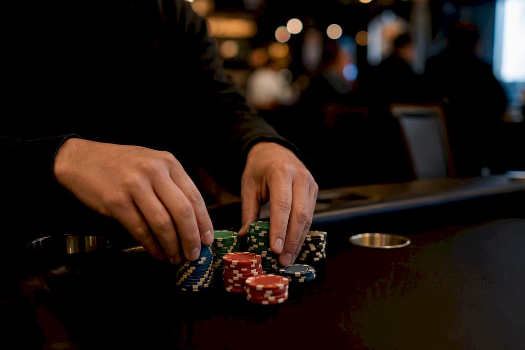 Hands adjusting betting chips on table