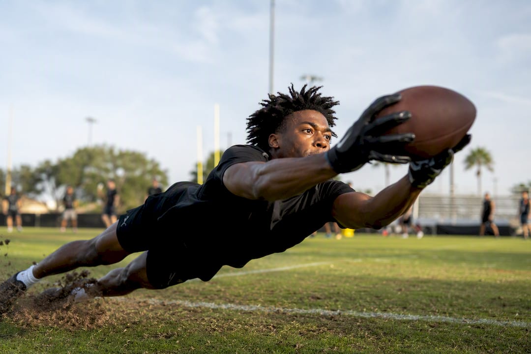Rookie wide receiver catching ball on practice field