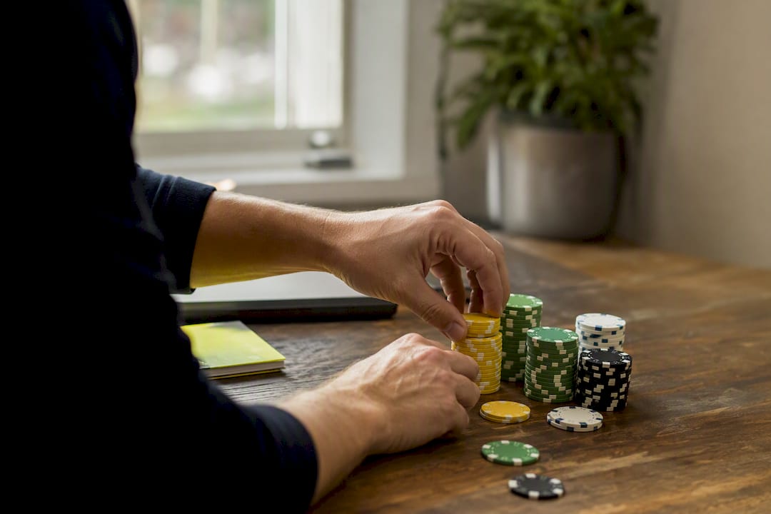 Hands stacking betting chips for bankroll management