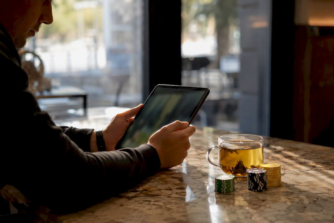 Hands holding tablet showing soccer betting data