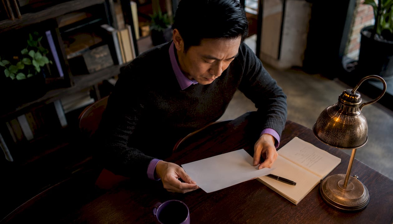Man reviewing printed book title options in office
