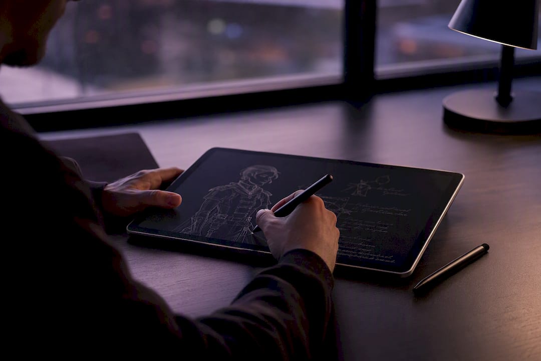 Hands sketching character silhouette on tablet