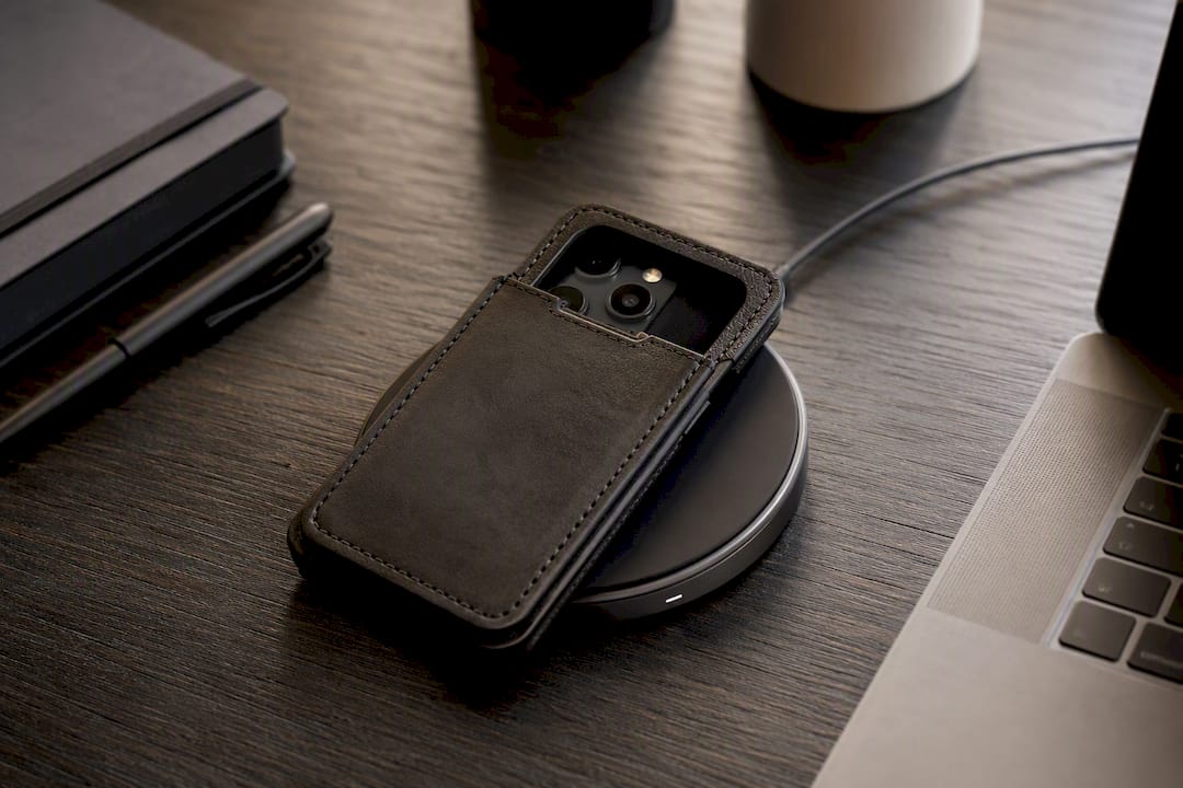 Telefon mit dickem Lederetui auf kabellosem Ladegerät