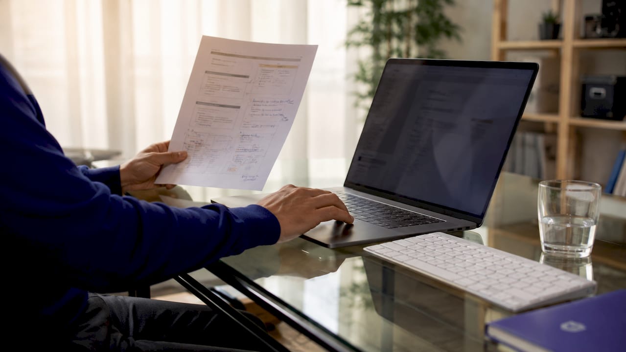 Hands troubleshooting DNS records on tablet and printouts