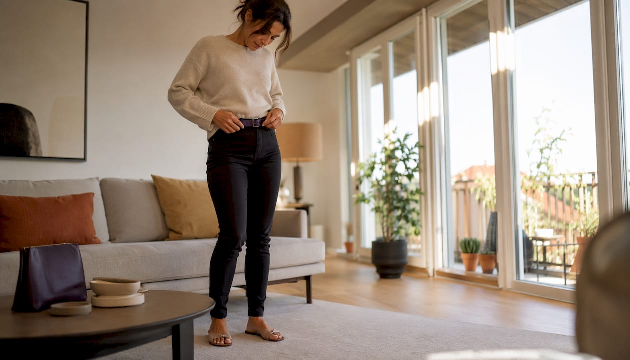 Eine Frau zeigt, wie sie ihre Slim Fit Jeans zuhause kombiniert.