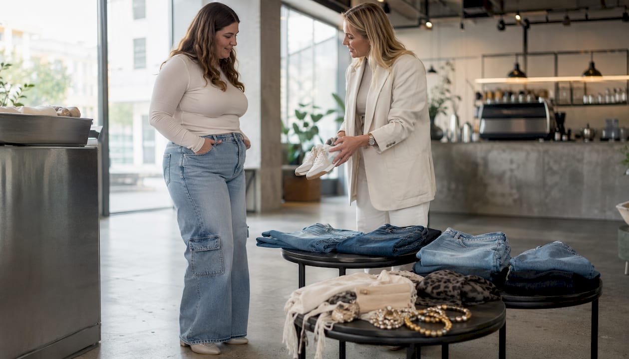 Vrouw gaat in gesprek met styliste over hoe je barrel jeans het beste kunt combineren