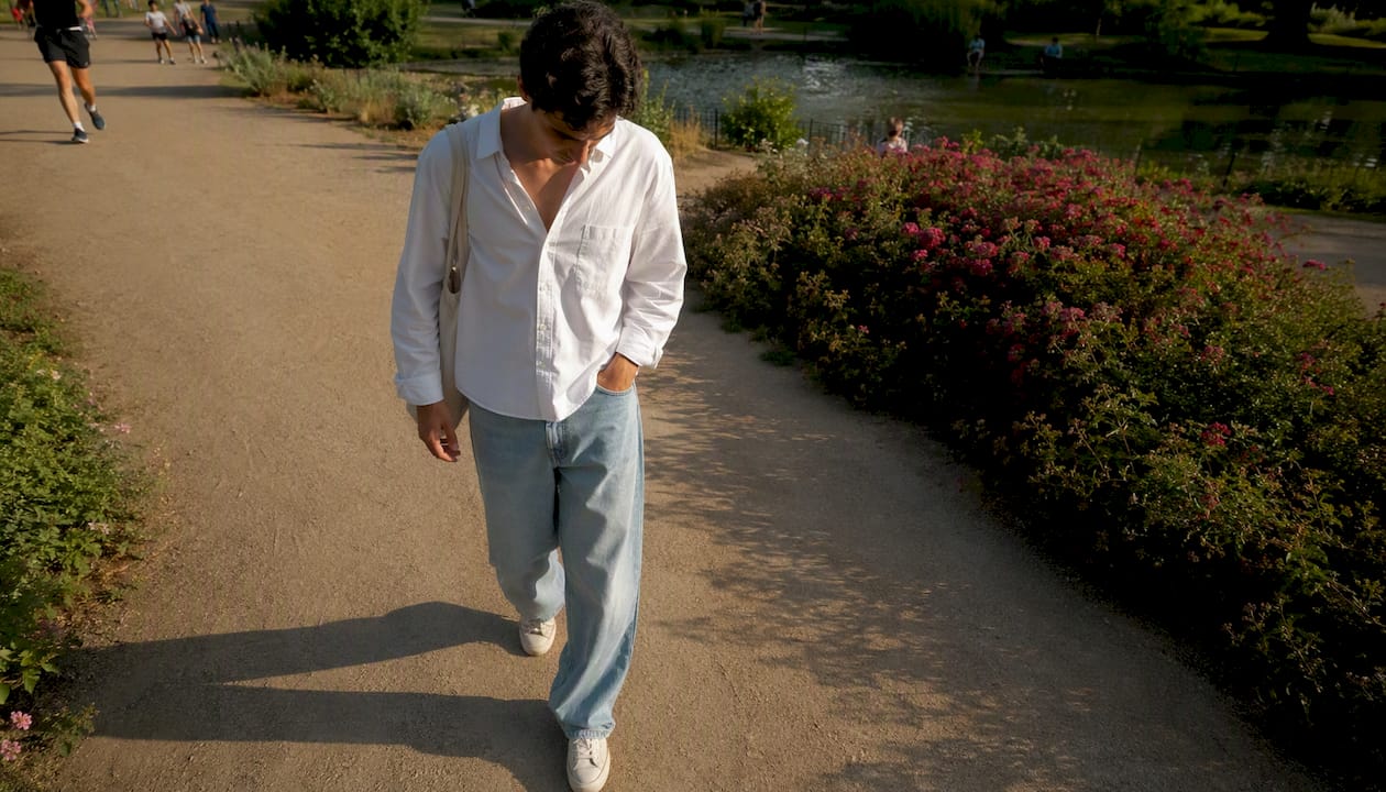 Een man wandelt door het park in een luchtige, losse zomerbroek.