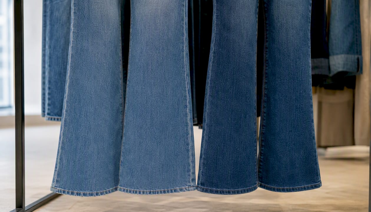 Detailopname van de onderkant van een flare en een bootcut jeans, met extra aandacht voor de afwerking en snit van de pijpen.