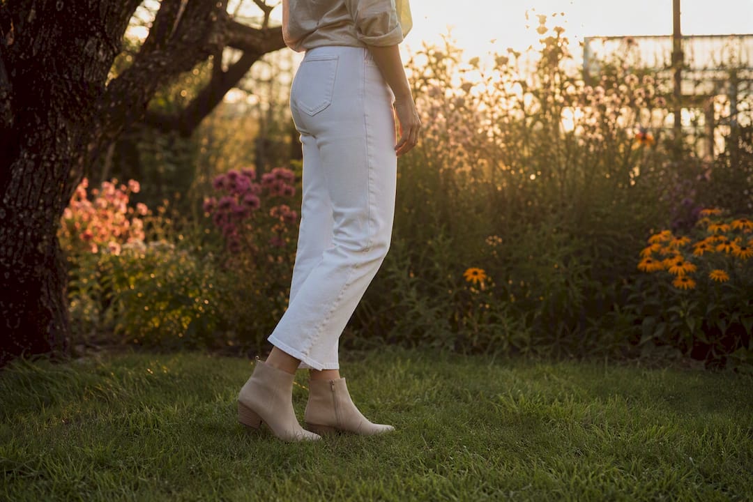 Cropped-Jeans über knöchelhohen Stiefeln im Freien