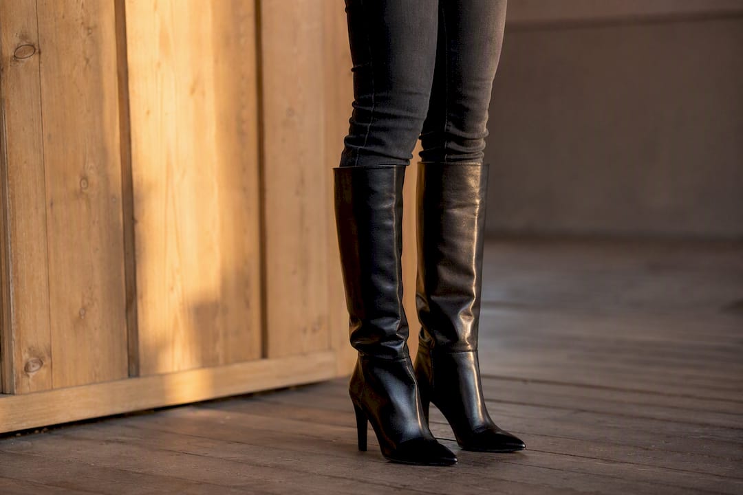 Zwarte skinny jeans gecombineerd met kniehoge laarzen