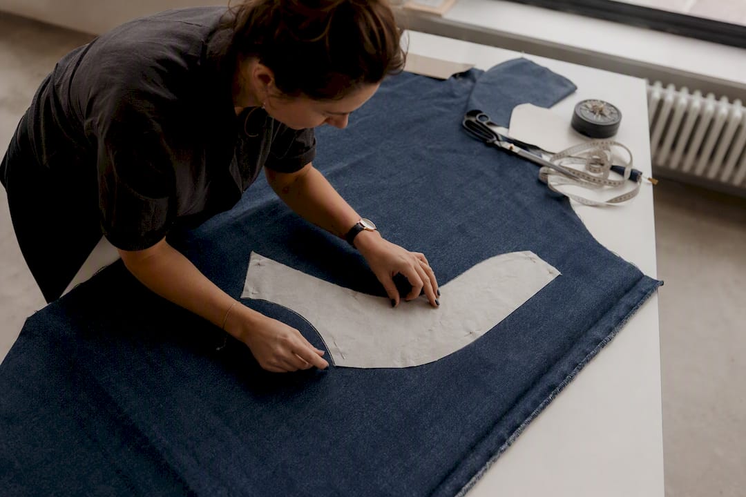 Handen die een curvy fit inzetstuk op denim positioneren