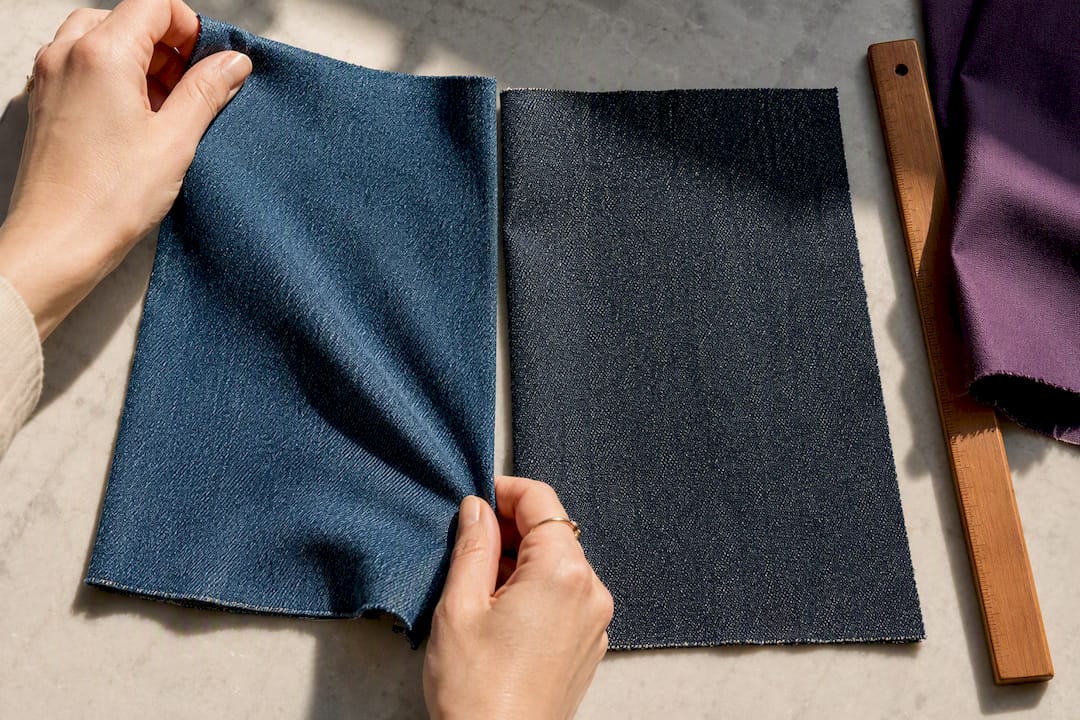 Hände vergleichen Stretch-Jeans mit festem Denim