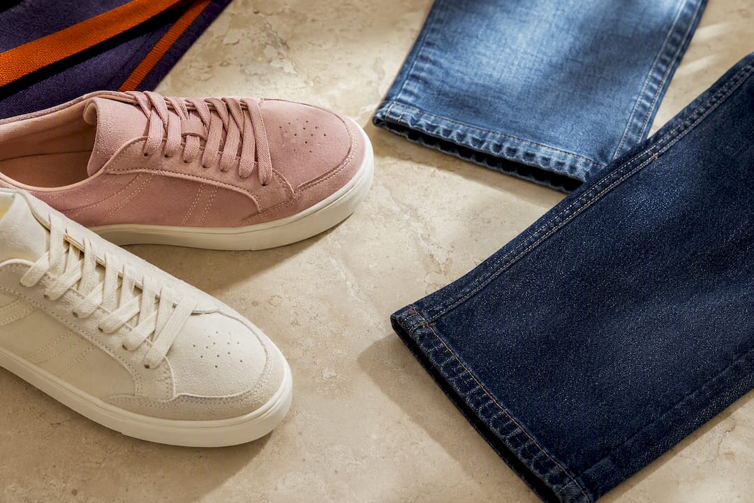 Off-White- und Altrosa-Sneaker neben Denim