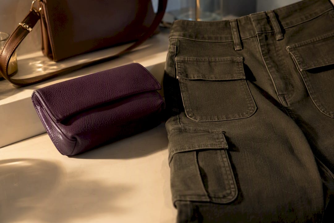 Clutch neben auffälligen Cargo-Taschen