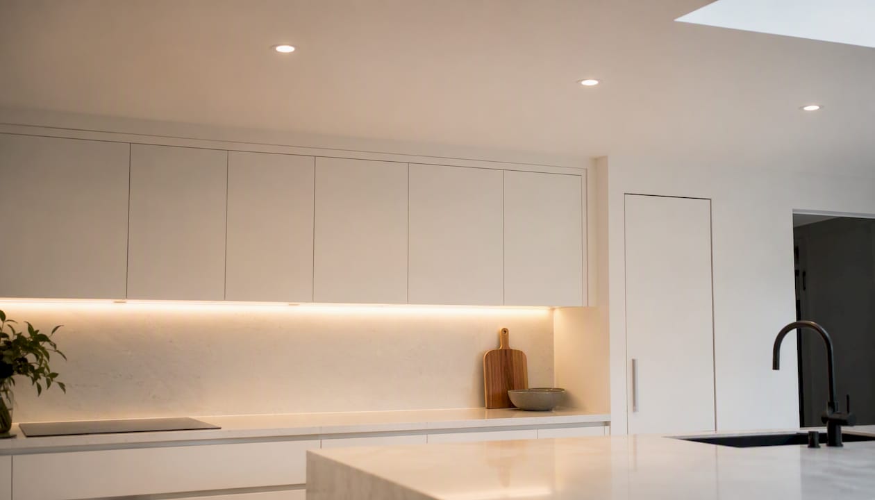Recessed downlights spaced over kitchen benchtop