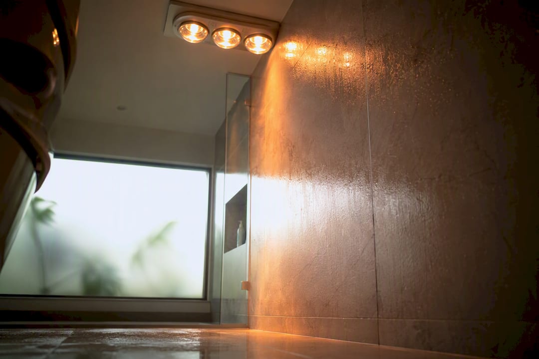 Ceiling heat lamp providing radiant warmth in bathroom