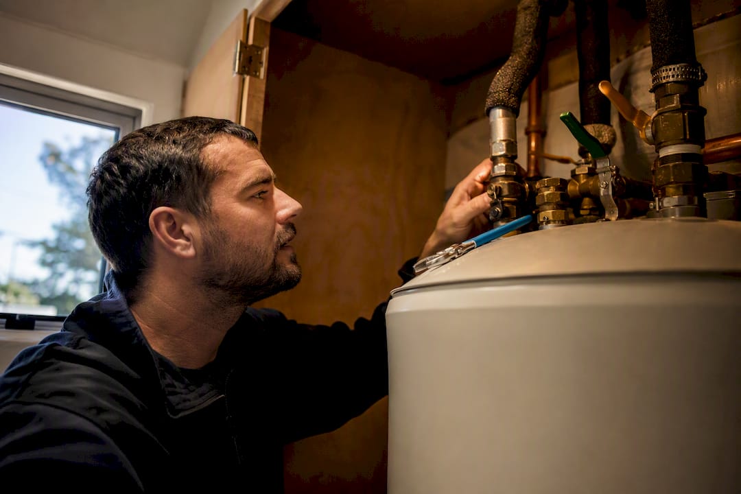 Installer checking hot water cylinder connections