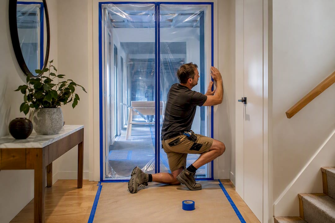 Builder sealing plastic dust barrier doorway