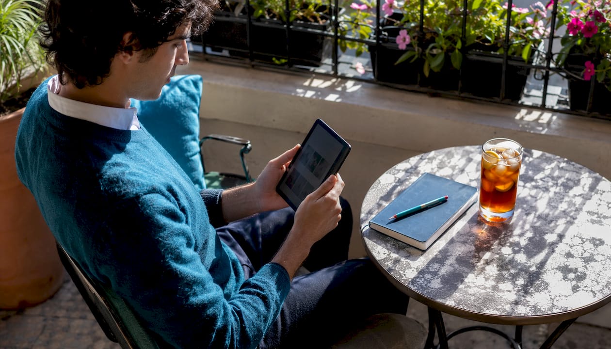 Side profile of person browsing ebook on Kobo outside cafe