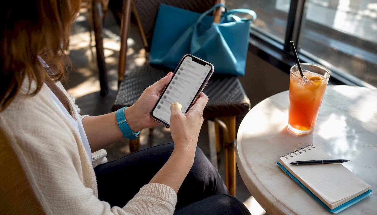Hands scrolling book deal newsletter on phone