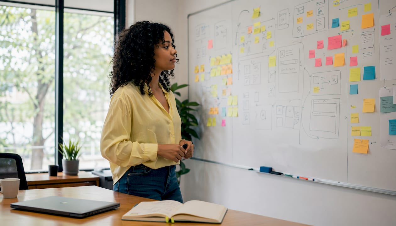 Hands prioritizing UX issues on sticky notes