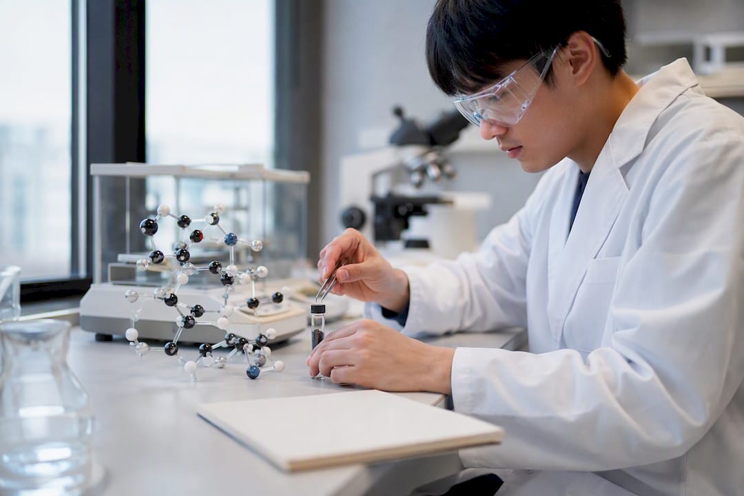 Hands placing nanoparticle vial in research lab