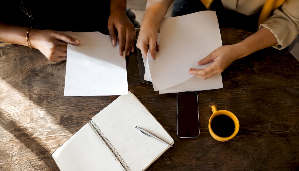Varias manos trabajando en equipo sobre la mesa de una clínica