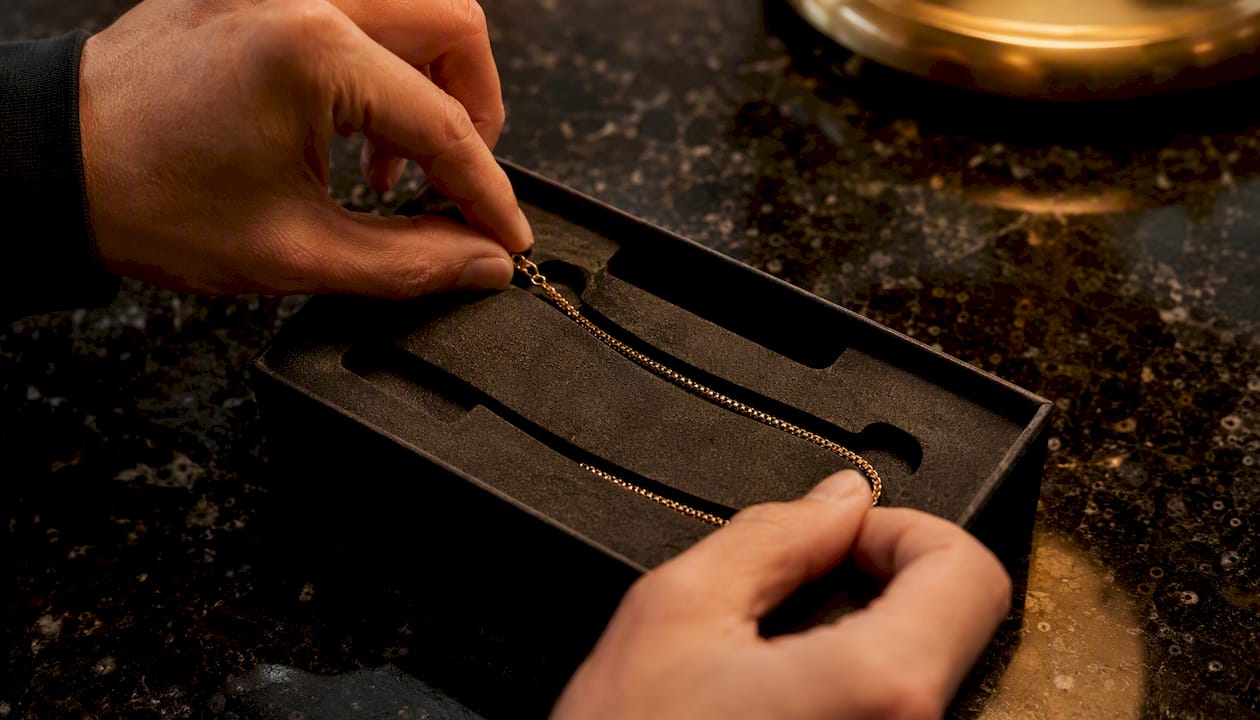 Hands testing jewelry chain fit in foam insert