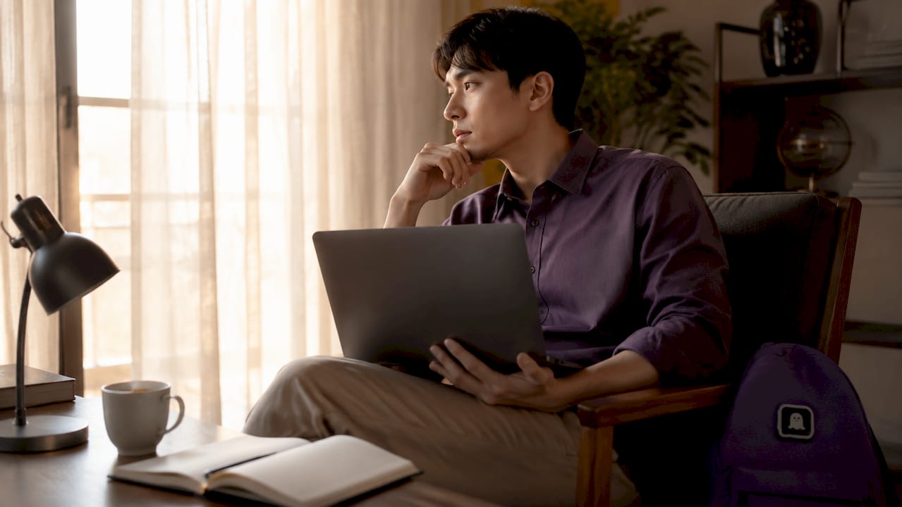 Man pausing thoughtfully with phone in hand