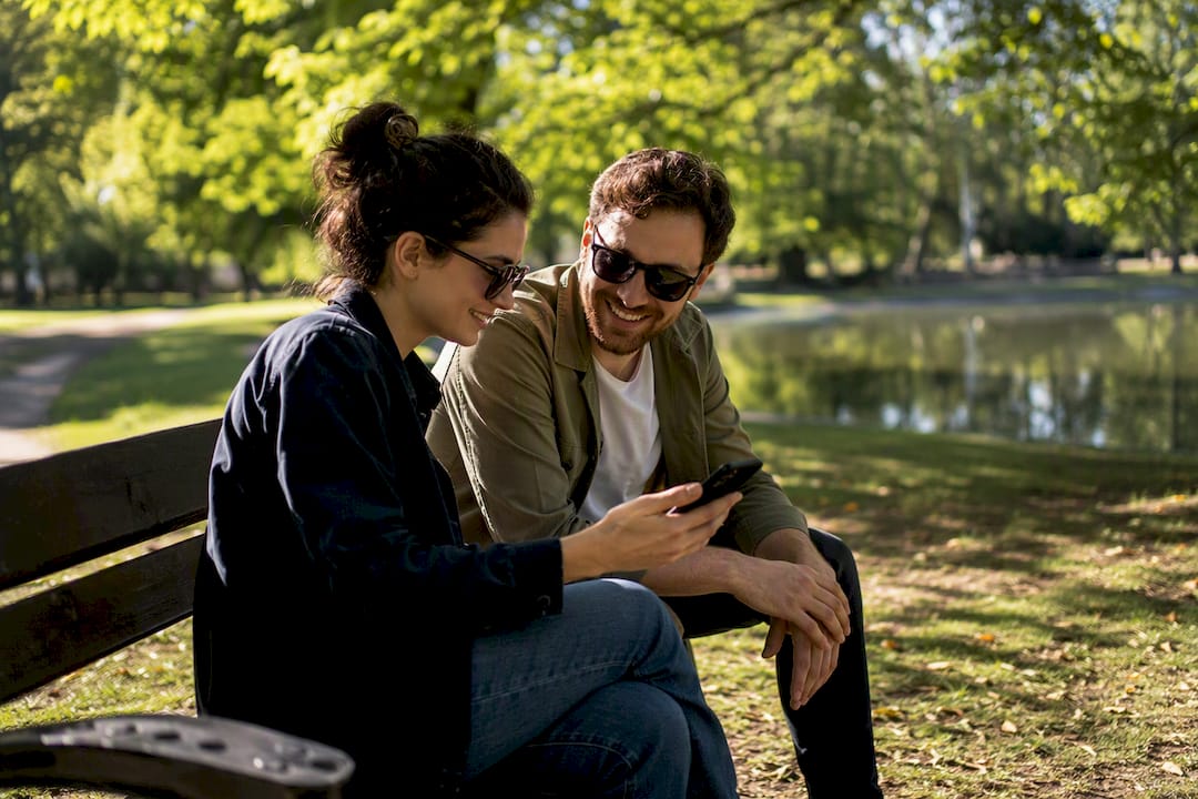 Two friends sharing warm moment with phone