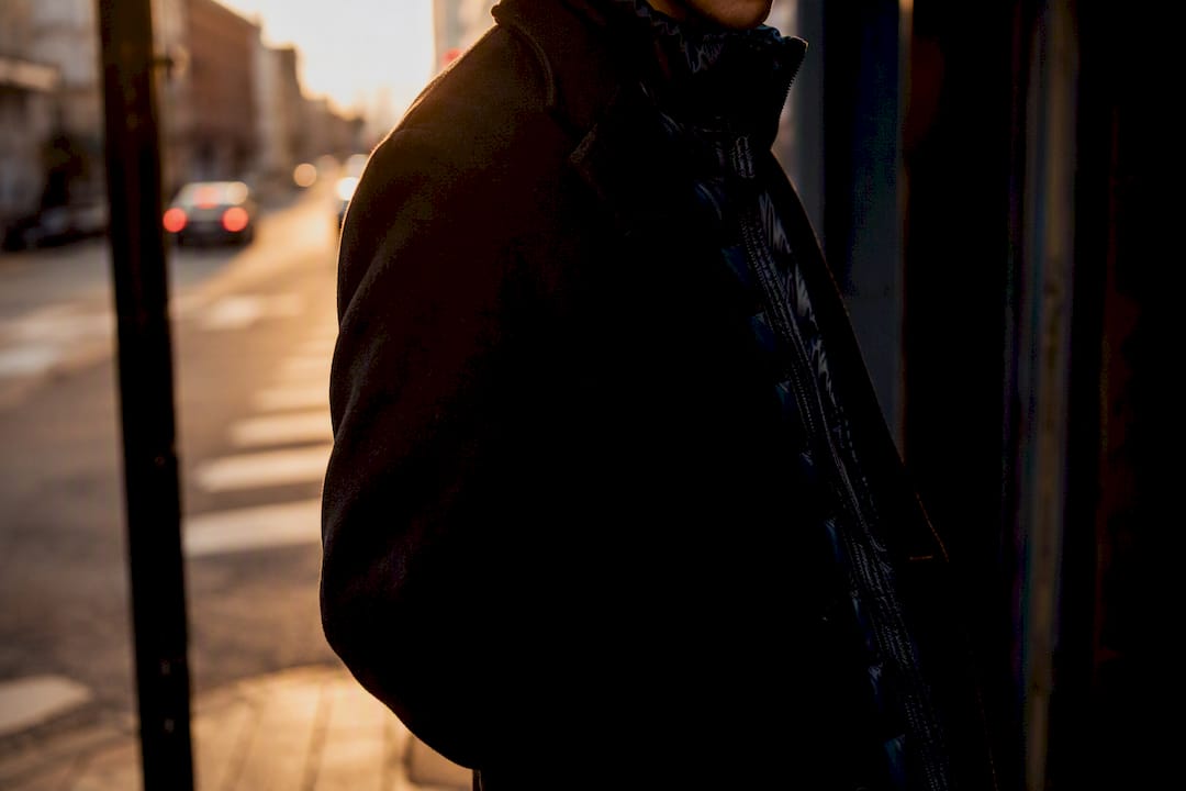 Matte wool coat layered over shiny nylon puffer