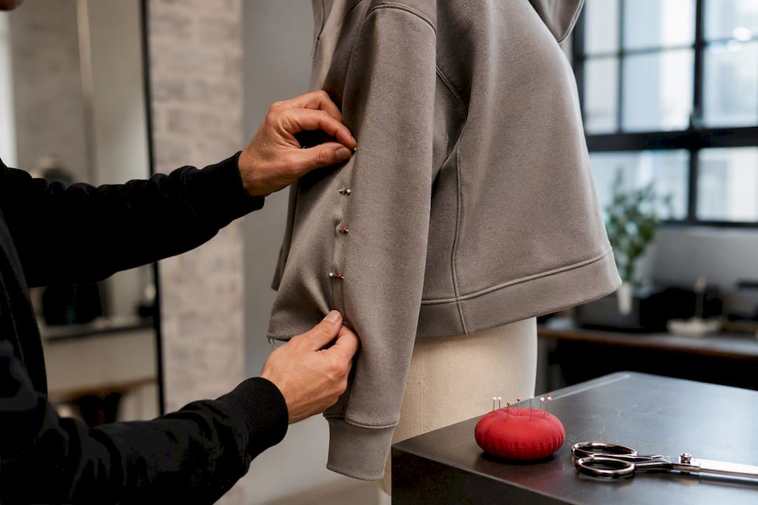 Tailor pinning a hoodie side seam