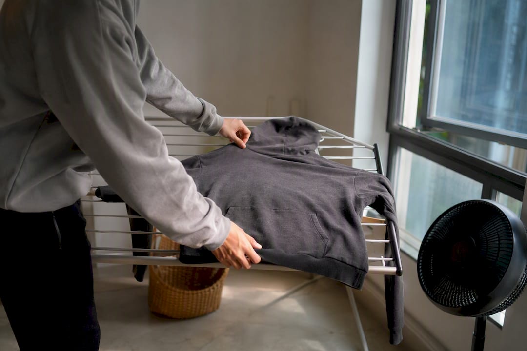 Hoodie drying on indoor rack in shade