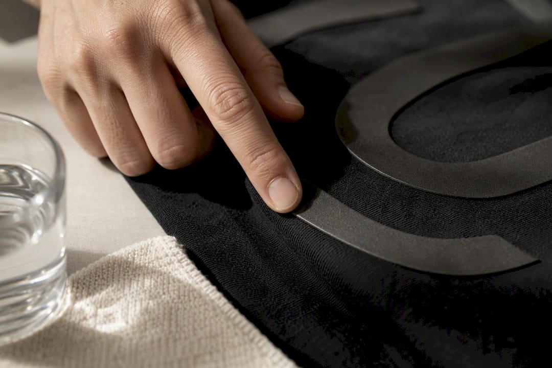 Finger checking a raised T-shirt print texture