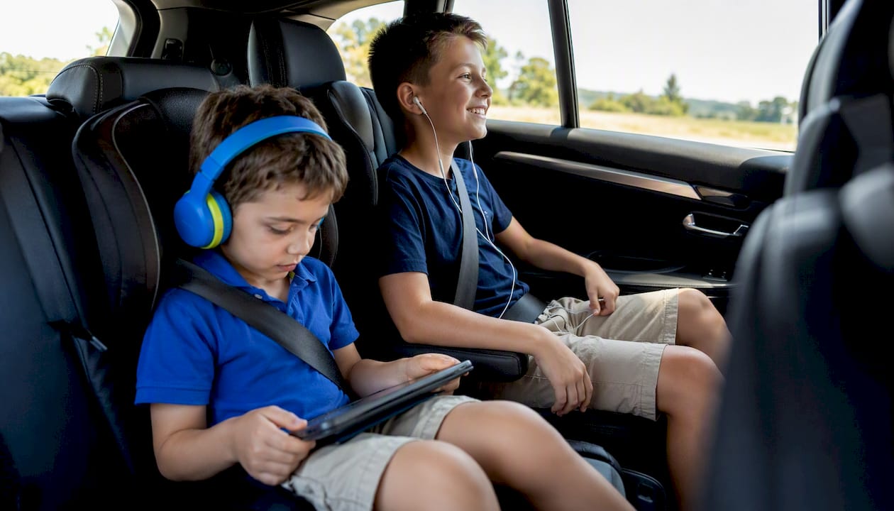 Children listening to podcasts in car seats
