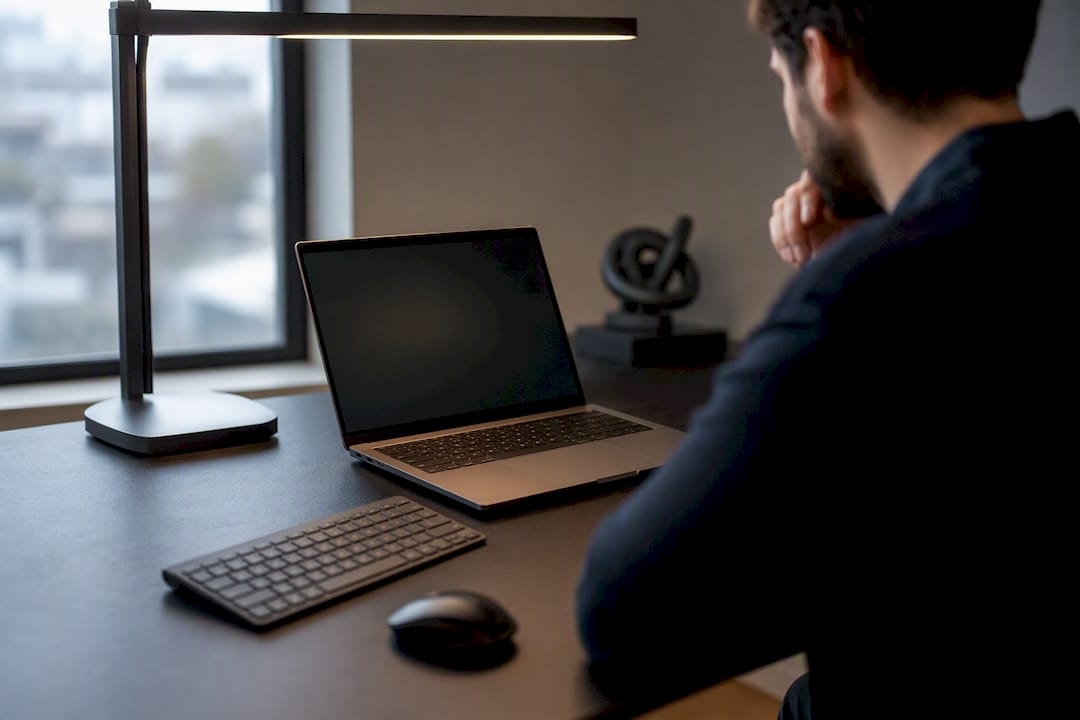 Dark laptop screen in dimly lit tech workspace
