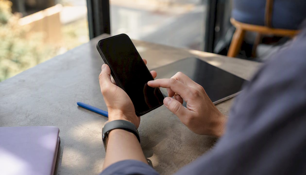 Hands manually testing smartphone with screen off