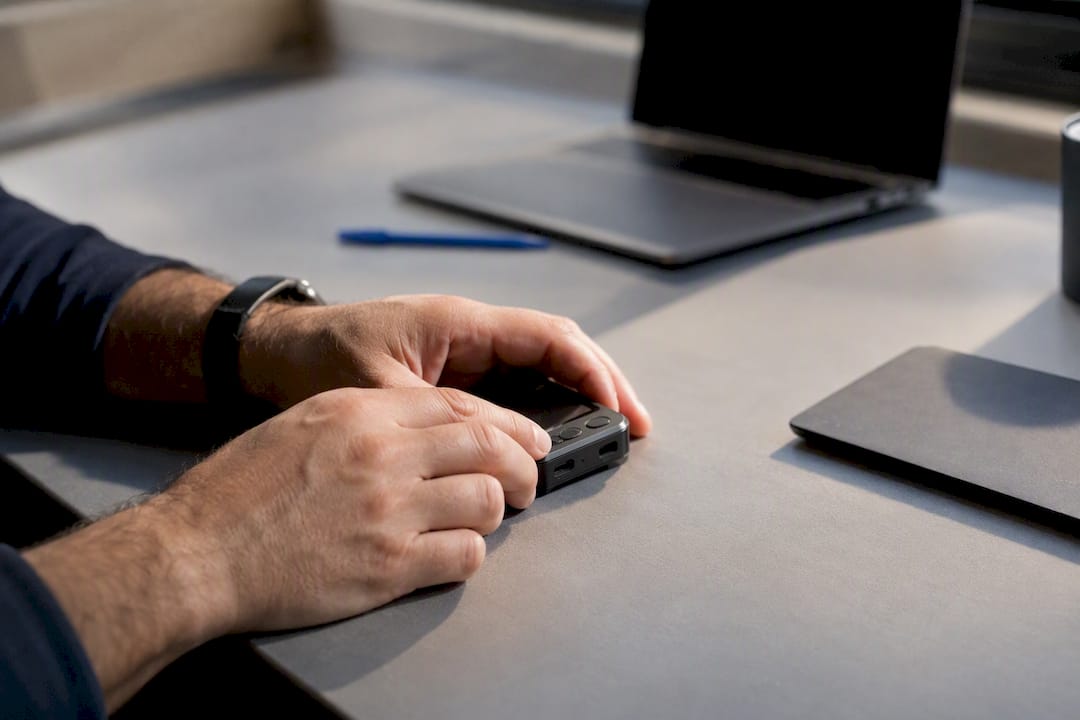 Hands adjusting small device on desk
