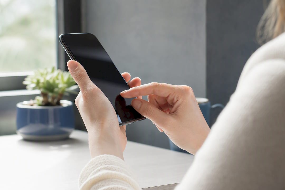 Hands tapping smartphone edge preparing to sign